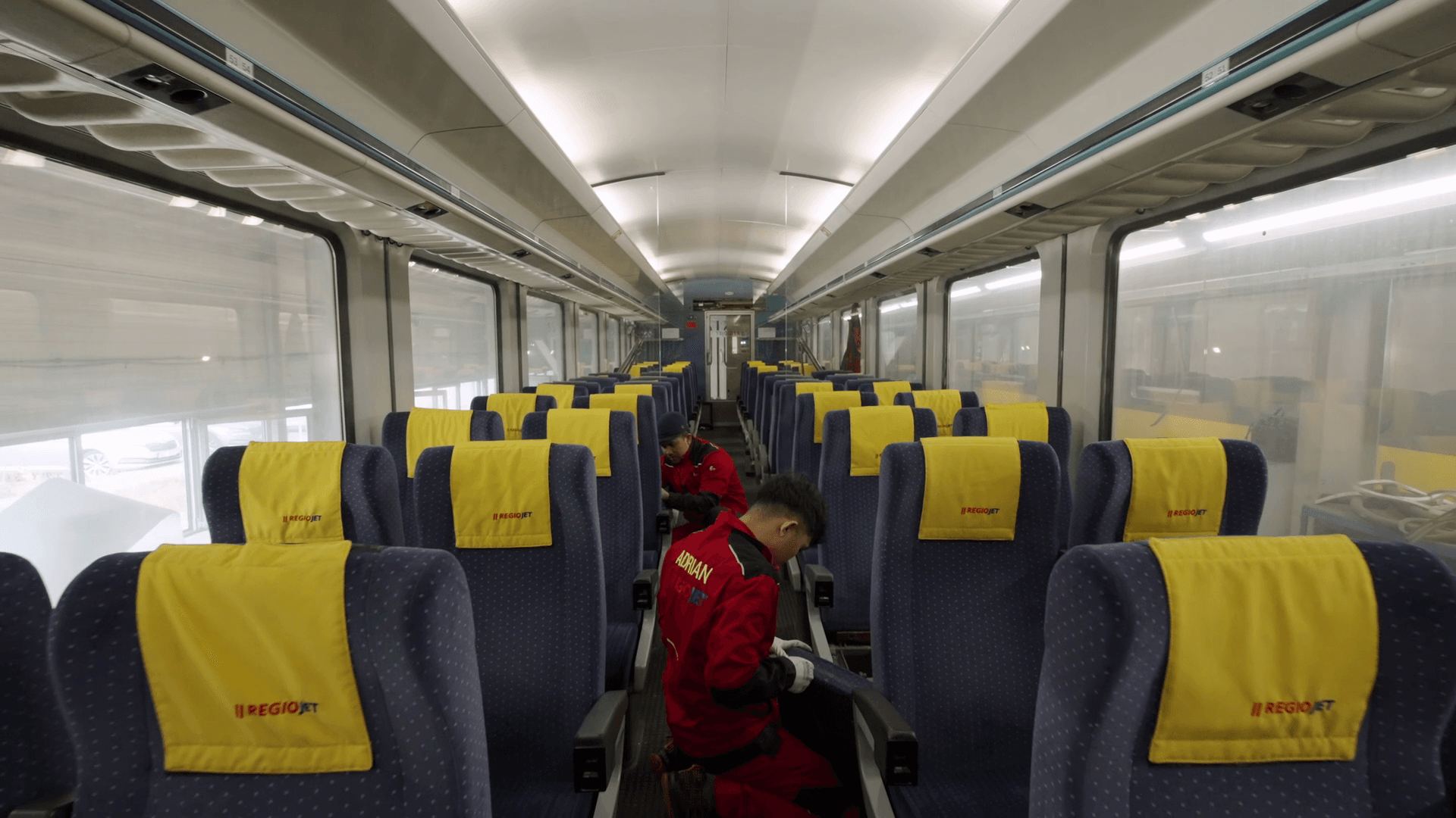 A worker preparing the seats in a carriage between services