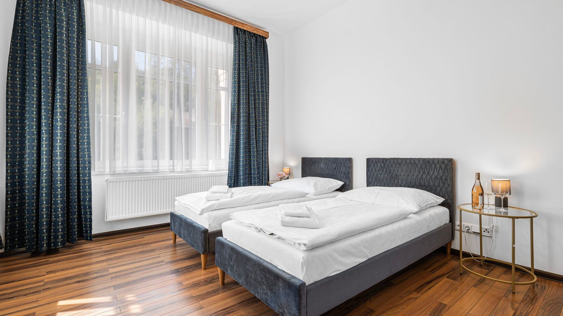 Twin room in the accommodation with hotel bedding and a wooden floor